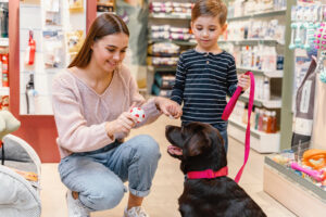 Foto ilustrativa de uma mãe, seu filho e seu cachorro em um pet shop