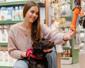 Foto de uma mulher com seu cachorro em um pet shop