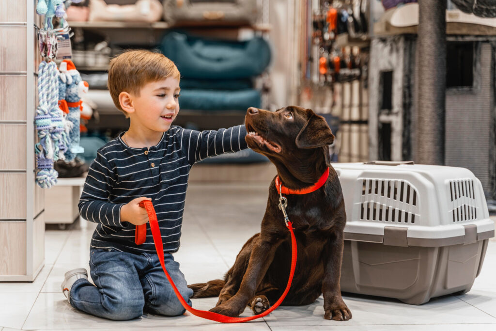 Foto de um menino fazendo carinho em um cachorro em um pet shop