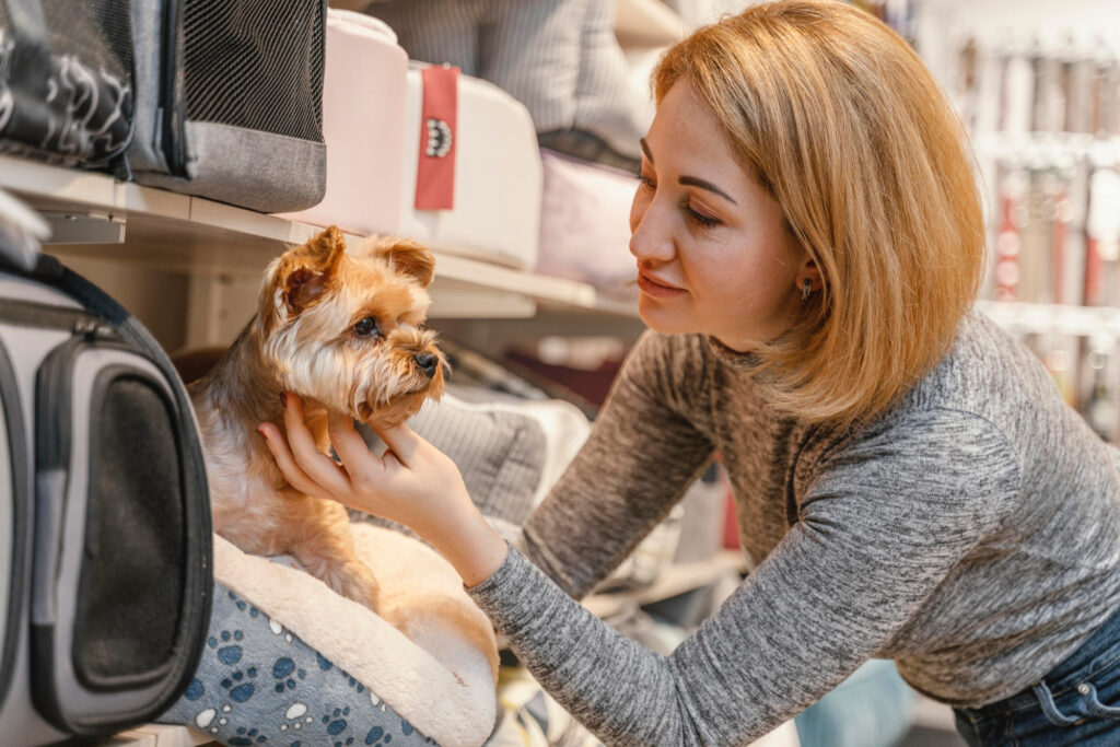 Foto de uma mulher e um yorkshire em um pet shop