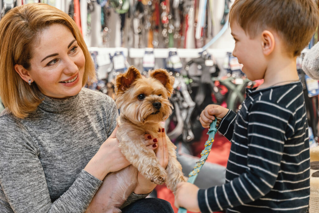 Mãe e filho com seu cachorro de estimação em um pet shop